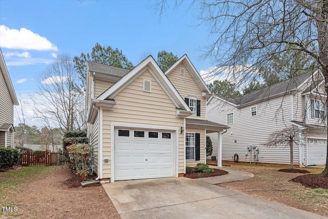 view of front of home with concrete driveway, fence, and a garage