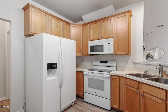 kitchen featuring visible vents, light countertops, light wood-style flooring, white appliances, and a sink