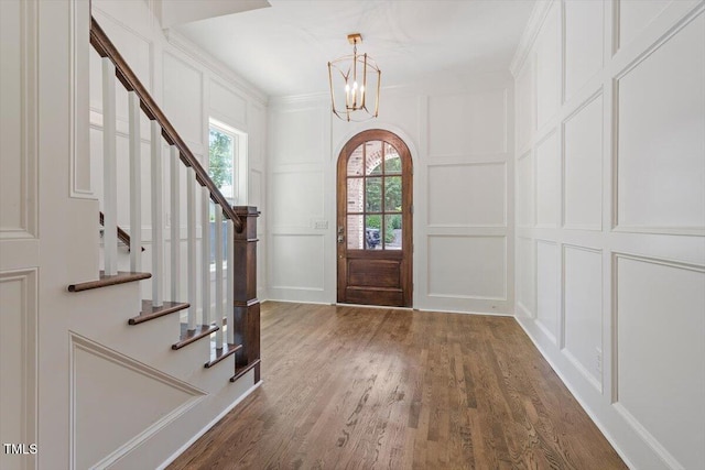 1608 Scales St, Raleigh, NC 27608 - entrance foyer with a decorative wall, wood finished floors, a chandelier, stairway, and crown molding