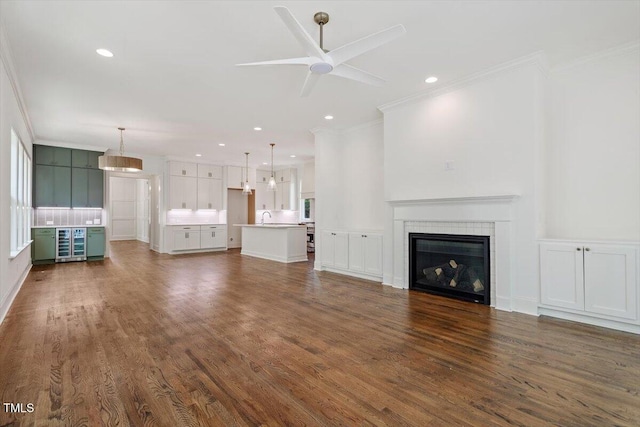 1608 Scales St, Raleigh, NC 27608 - unfurnished living room featuring ornamental molding, recessed lighting, a ceiling fan, a fireplace, and dark wood finished floors