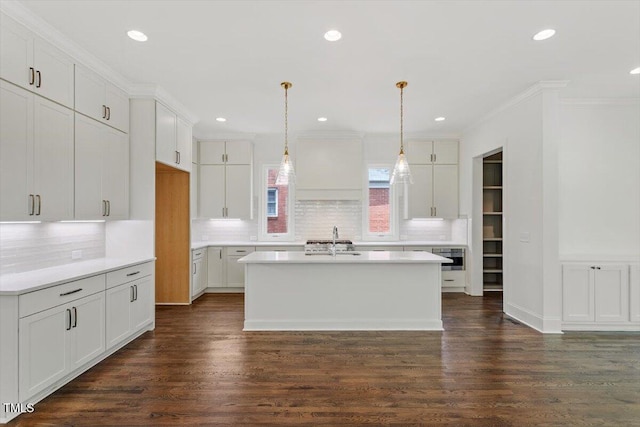 1608 Scales St, Raleigh, NC 27608 - kitchen featuring a sink, crown molding, white cabinetry, a center island with sink, and backsplash