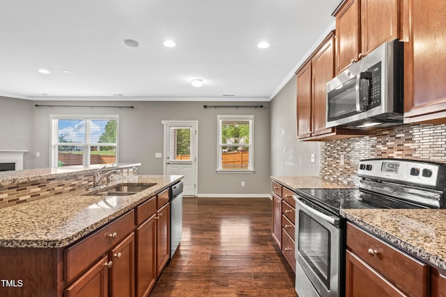 kitchen with a sink, stainless steel appliances, light stone countertops, and tasteful backsplash