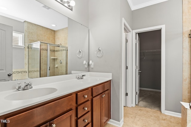 bathroom featuring a sink, double vanity, a stall shower, and a spacious closet