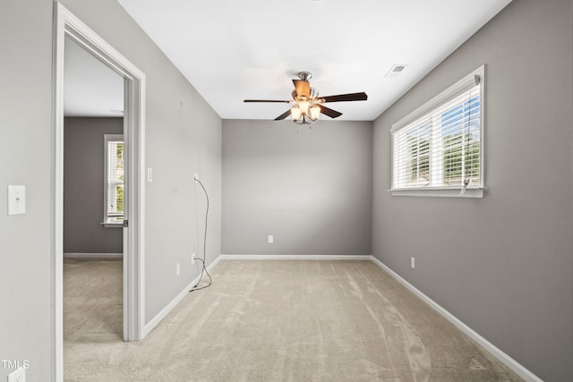 empty room with baseboards, carpet floors, a healthy amount of sunlight, and ceiling fan