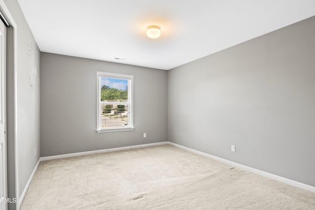 spare room with visible vents, carpet floors, and baseboards