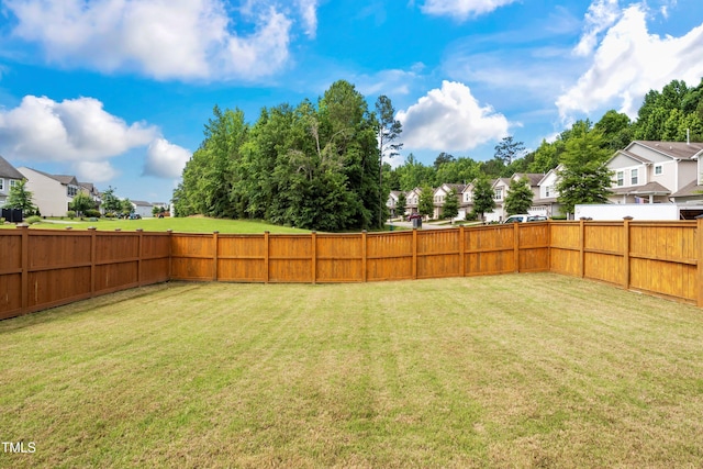 view of yard featuring a fenced backyard and a residential view