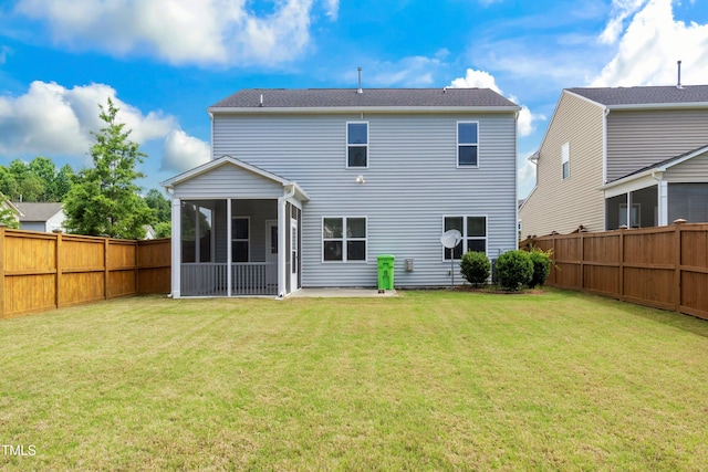 rear view of property with a lawn, a fenced backyard, and a sunroom