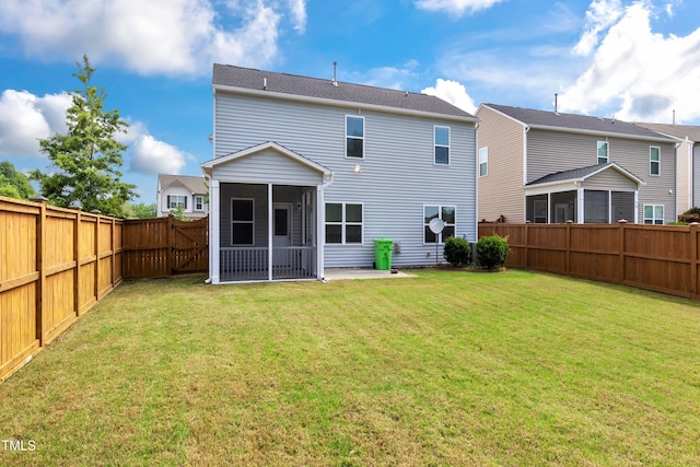 rear view of property featuring a fenced backyard, a lawn, and a sunroom