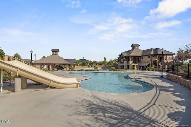 pool featuring a gazebo, fence, and a patio