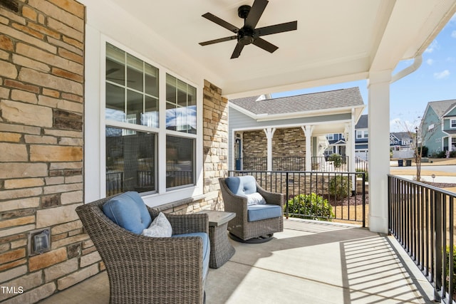 balcony with a porch, a ceiling fan, and a residential view