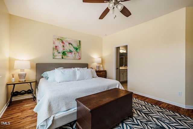 bedroom featuring ensuite bath, baseboards, and wood finished floors