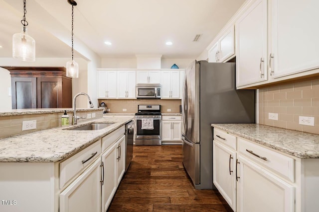 kitchen with a sink, tasteful backsplash, appliances with stainless steel finishes, white cabinets, and dark wood-style flooring