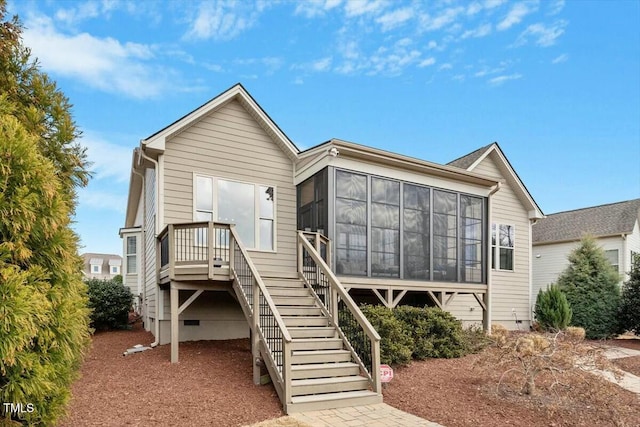 rear view of house with crawl space, stairs, and a sunroom