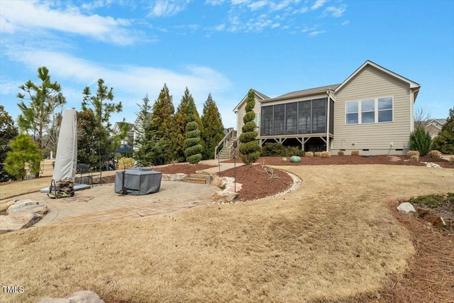 rear view of property featuring stairs, a patio, a sunroom, and crawl space