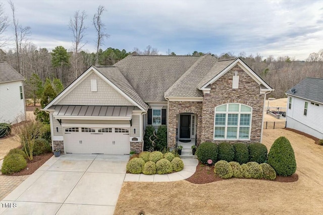 craftsman house with a garage, driveway, a standing seam roof, and stone siding