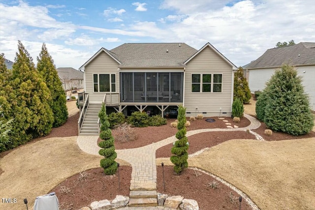 rear view of property with driveway, stairway, roof with shingles, a sunroom, and crawl space