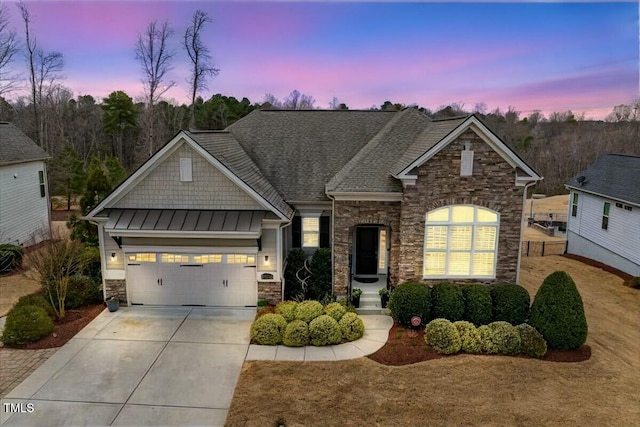 craftsman house featuring a standing seam roof, concrete driveway, a garage, stone siding, and metal roof