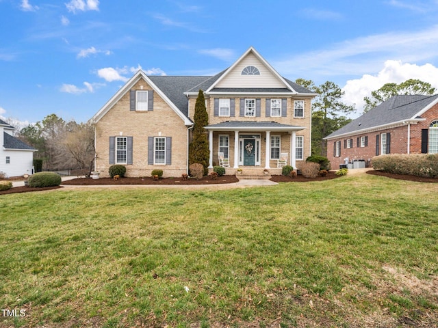 neoclassical home featuring brick siding and a front lawn