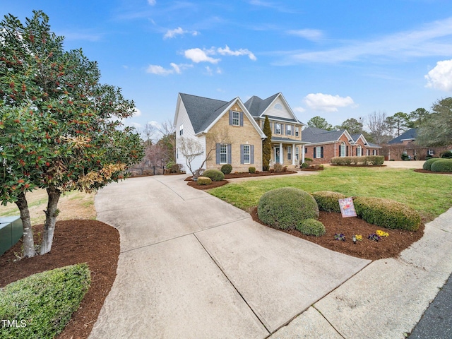 view of front of property with stone siding, driveway, a front lawn, and fence