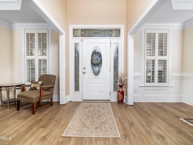 entrance foyer featuring light wood-style floors and ornamental molding