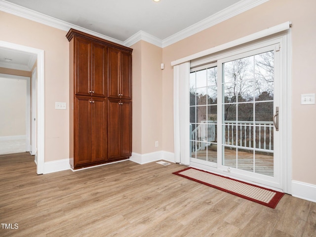 doorway with light wood-style floors, baseboards, and ornamental molding