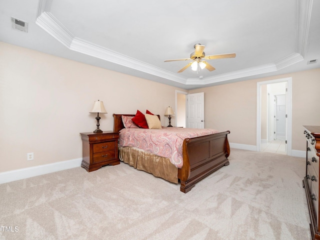 bedroom featuring visible vents, a raised ceiling, and light colored carpet