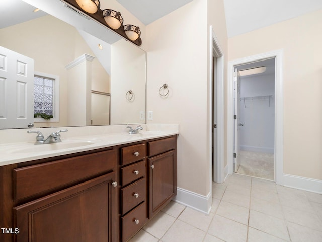 full bath with double vanity, tile patterned flooring, lofted ceiling, and a sink