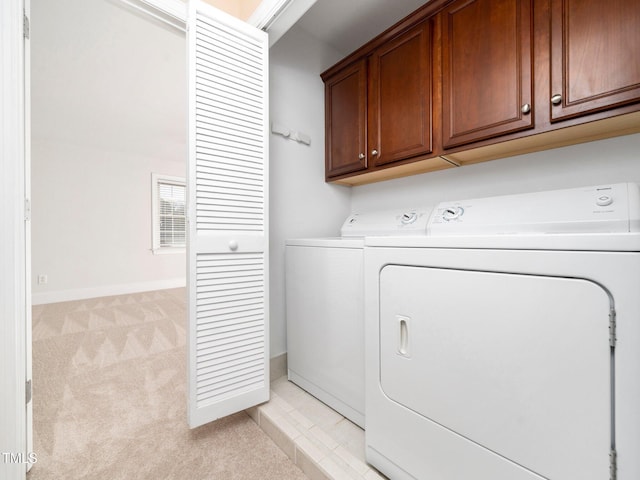 washroom with washer and dryer, baseboards, cabinet space, and light carpet