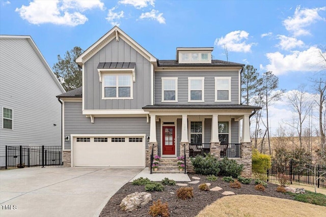 craftsman house with a porch, board and batten siding, driveway, and fence