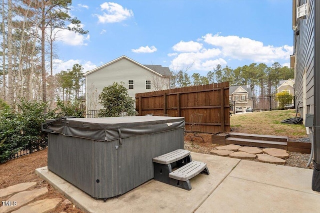 view of patio featuring fence and a hot tub