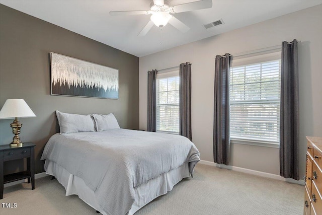 bedroom with visible vents, baseboards, light colored carpet, and a ceiling fan