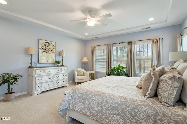 bedroom with a ceiling fan, baseboards, visible vents, a raised ceiling, and light colored carpet