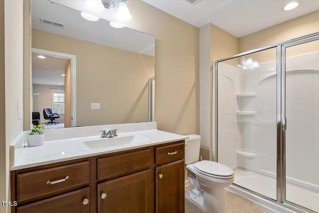 bathroom with vanity, toilet, visible vents, and a stall shower