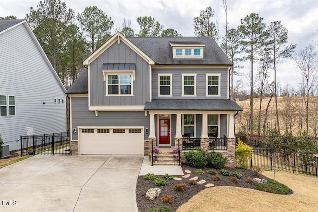 craftsman-style home featuring fence, covered porch, board and batten siding, and driveway