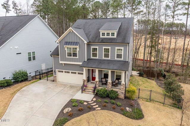 craftsman-style home with a porch, board and batten siding, driveway, and fence