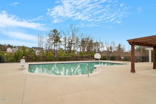 community pool with a patio area and fence