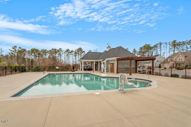 pool with a patio and fence