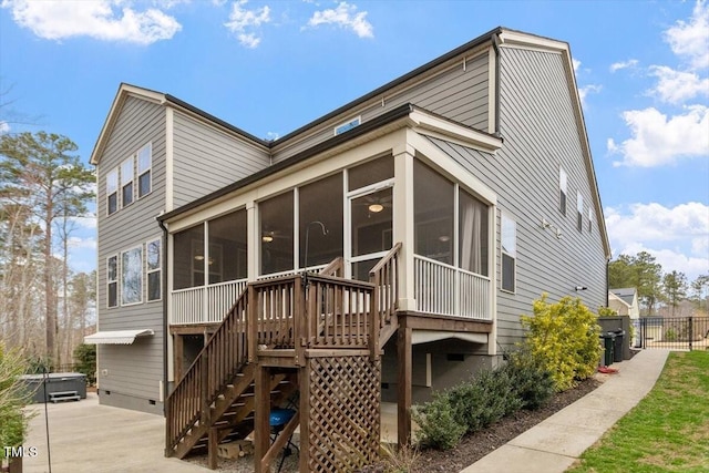 back of house featuring crawl space, stairway, a sunroom, and fence