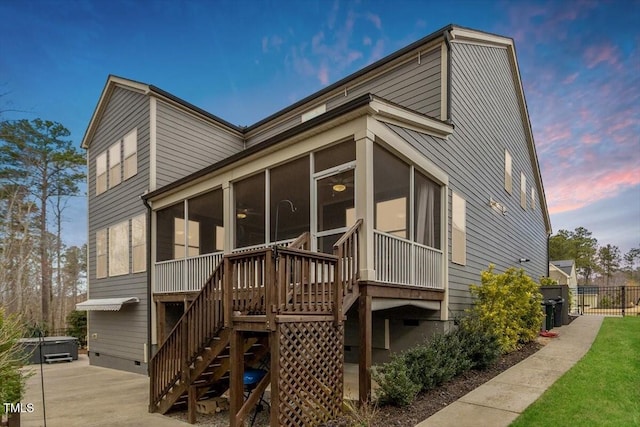 back of house at dusk with a patio, stairway, fence, a sunroom, and crawl space