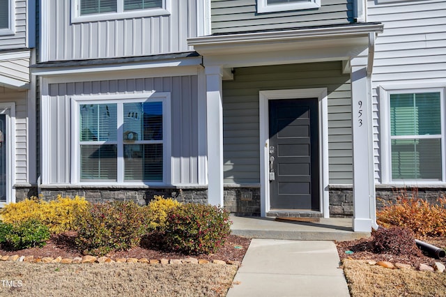 entrance to property featuring stone siding and board and batten siding