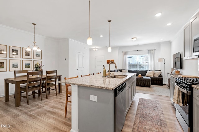 kitchen with a sink, crown molding, light wood-style flooring, and stainless steel appliances