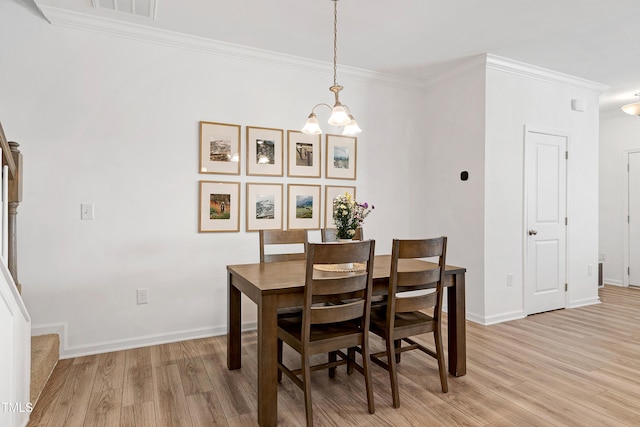 dining room featuring light wood-style floors, ornamental molding, and stairs