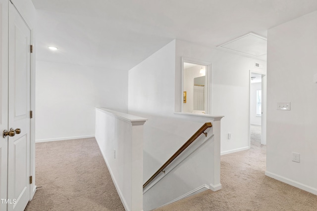 hall with baseboards, an upstairs landing, and carpet