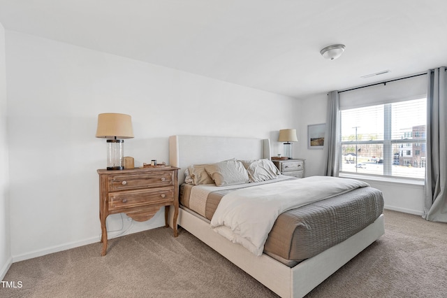 bedroom featuring visible vents, light colored carpet, and baseboards