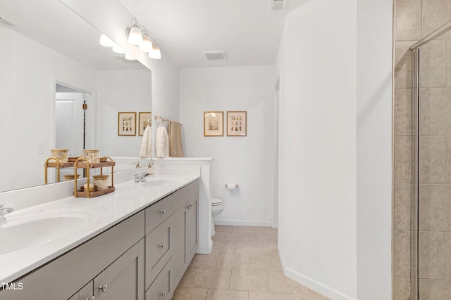 bathroom with visible vents, toilet, tiled shower, tile patterned floors, and a sink