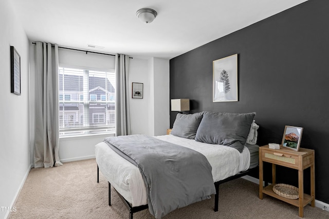 bedroom with baseboards and light colored carpet