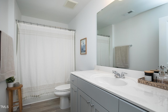 bathroom featuring visible vents, toilet, vanity, and wood finished floors