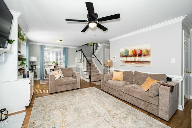 living room featuring stairway, crown molding, a ceiling fan, and wood finished floors