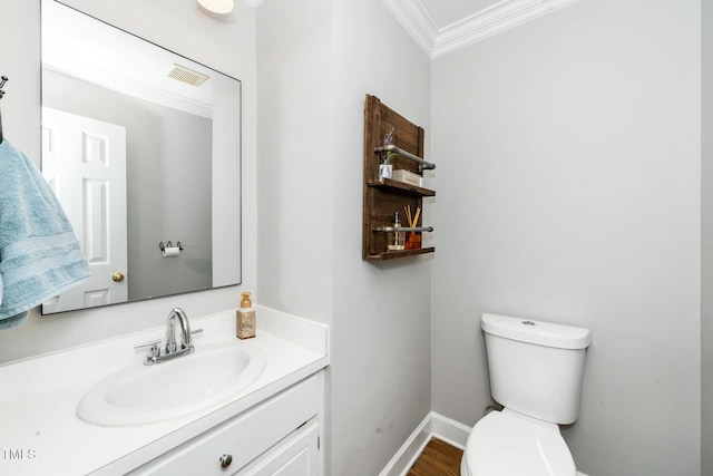 bathroom featuring visible vents, baseboards, toilet, ornamental molding, and vanity