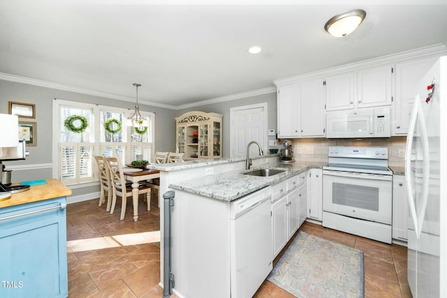 kitchen with tasteful backsplash, crown molding, a peninsula, white appliances, and a sink